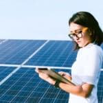 Eine Technikerin steht bei einer Solaranlage