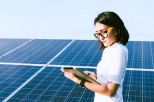 Eine Technikerin steht bei einer Solaranlage