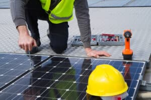 Ein Solartechniker bei der Installation eines PV-Moduls