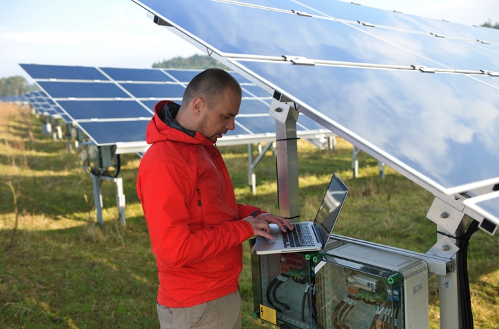 Ein Messtechniker steht bei einer Solaranlage