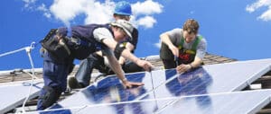 Installateure am Dach beim Bau einer Photovoltaikanlage
