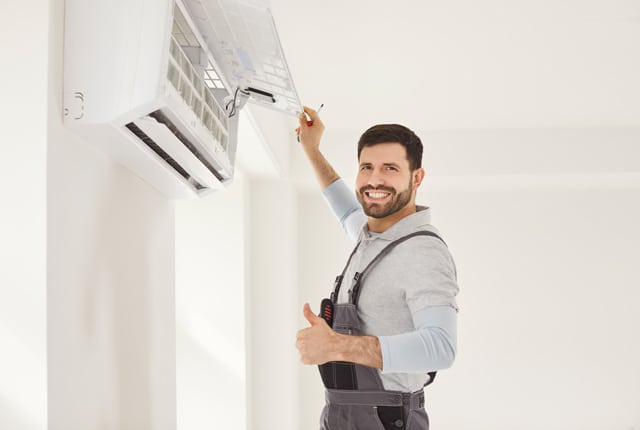 Ein Klimatechniker mit einer Klimaanlage